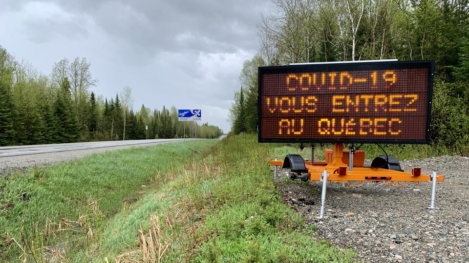 Une affiche lumineuse du MTQ indique «COVID-19 vous entrez au Québec».