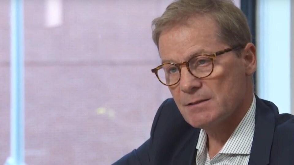 portrait d'une homme portant des lunettes.