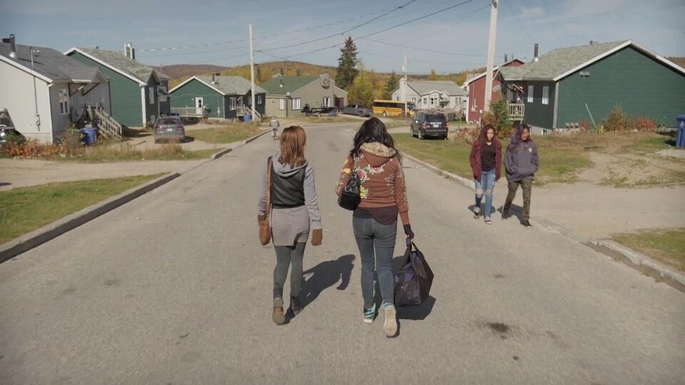 Fanny et Daisy marchent côte à côte au milieu d'une rue résidentielle à Manawan.