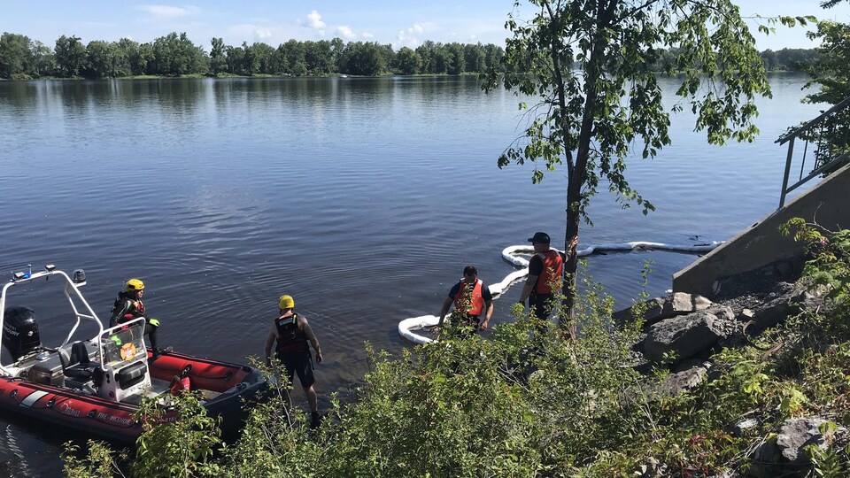 Des pompiers sur la rive de la rivière des Outaouais.