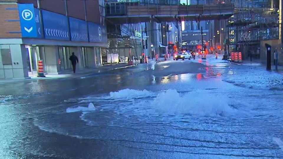 De l'eau jaillit du sol dans la rue.
