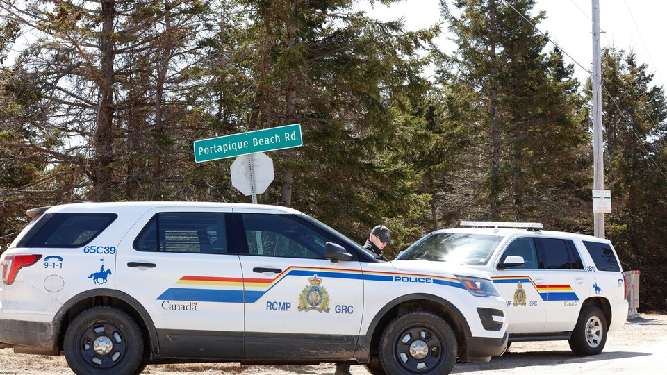 Deux véhicules de la GRC stationnés près d'une intersection pour bloquer la route.