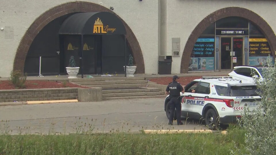 Une policière parle à un collègue dans une autopatrouille devant le bar-restaurant  ATL Lounge.
