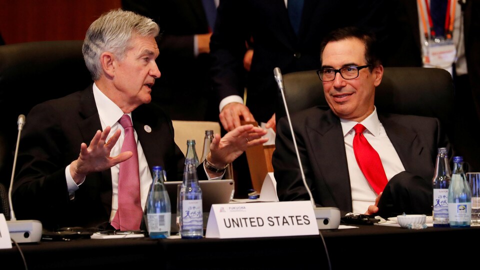 Les deux hommes sont assis, et Jerome Powell gesticule.