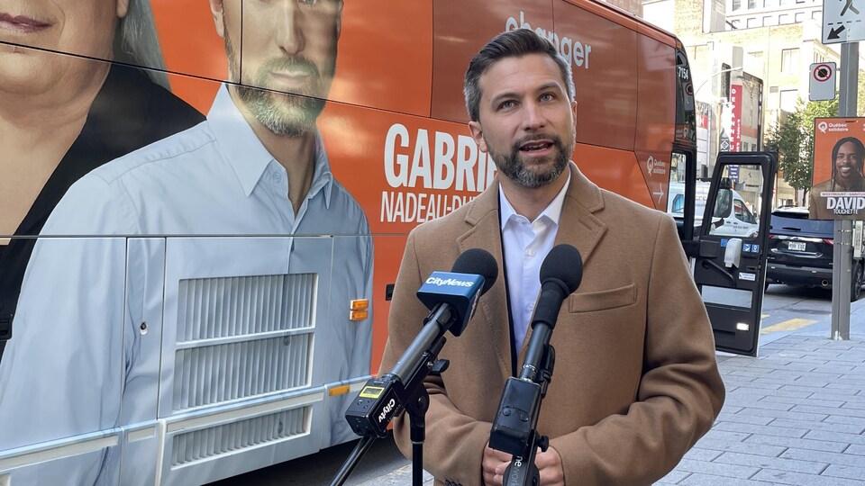 Gabriel Nadeau-Dubois devant son autobus de campagne.