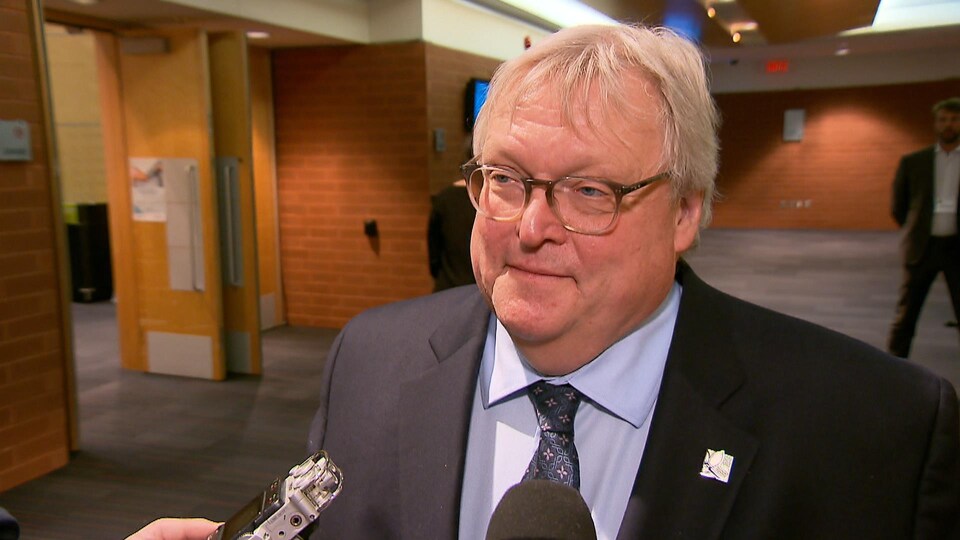 Gaétan Barrette répond aux questions des journalistes lors d’une mêlée de presse dans les couloirs du Centre des congrès de Québec.