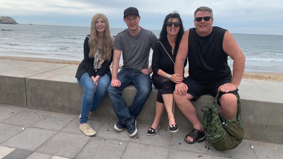 La famille pose pour une photo devant un lac.