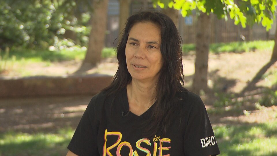 Une femme portant un chandail avec le logo du film « Rosie », en entrevue avec Radio-Canada.