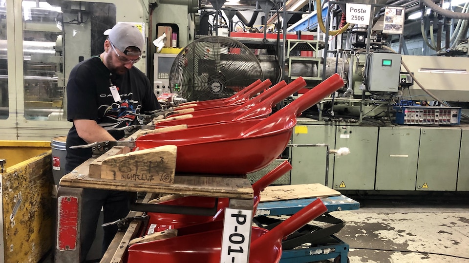 Un homme travaille dans une usine de pelles.