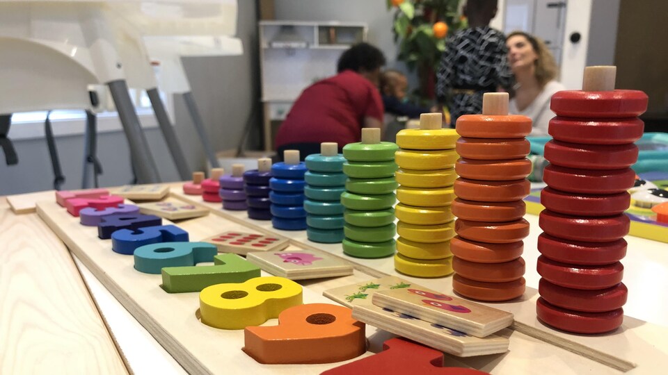 Un jeu avec des blocs de différentes couleurs pour apprendre à compter, placé sur une table dans une garderie.