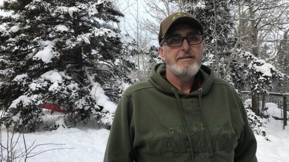 Gary Bath est debout devant des arbres enneigés.