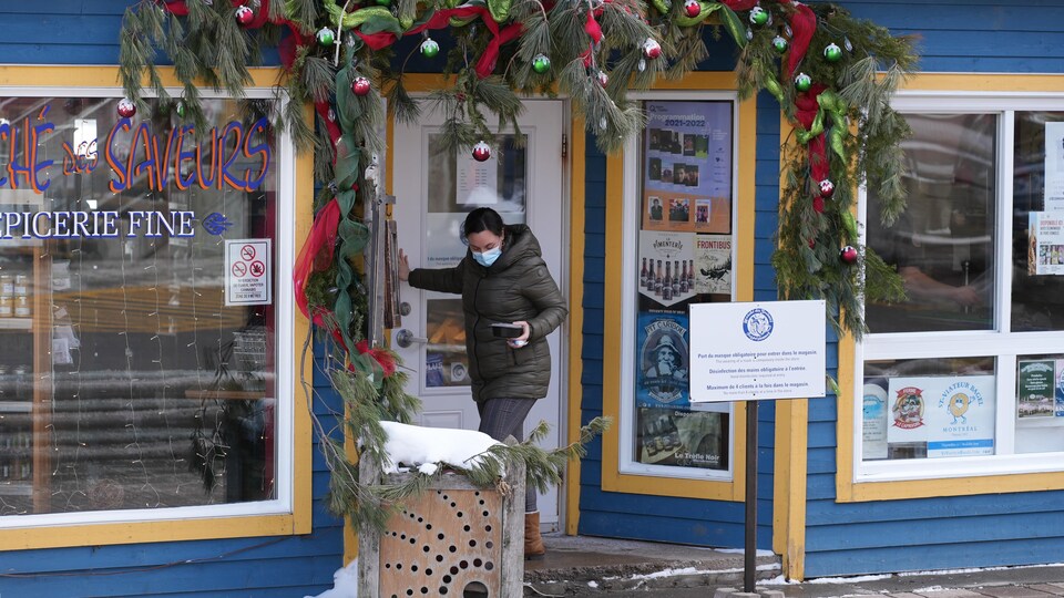 Une femme sort d'un commerce.