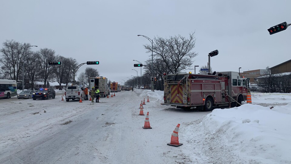 Des camions de pompiers dans une rue enneigée.