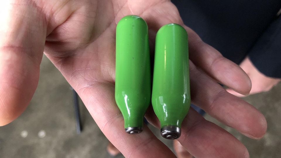 Gros plan sur deux bombonnes de couleur verte de la taille d'un doigt.