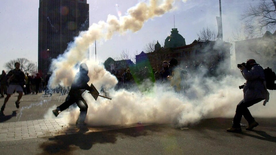 Un manifestant relance une grenade de gaz lacrymogène en direction des policiers.