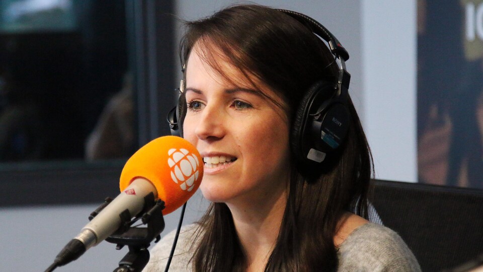 Geneviève O'Gleman devant un micro dans le studio d'ICI Québec.