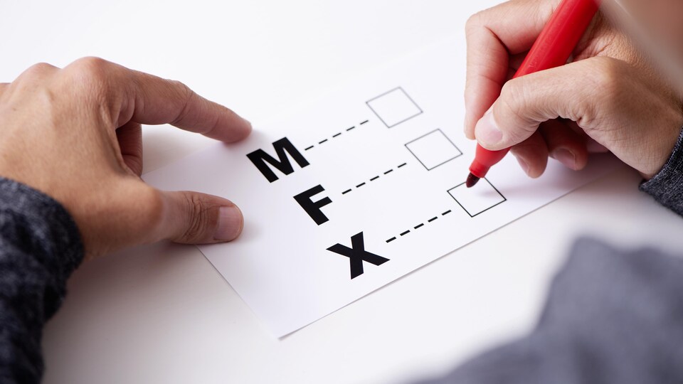 Une personne s'apprête à cocher une case M, F ou X.