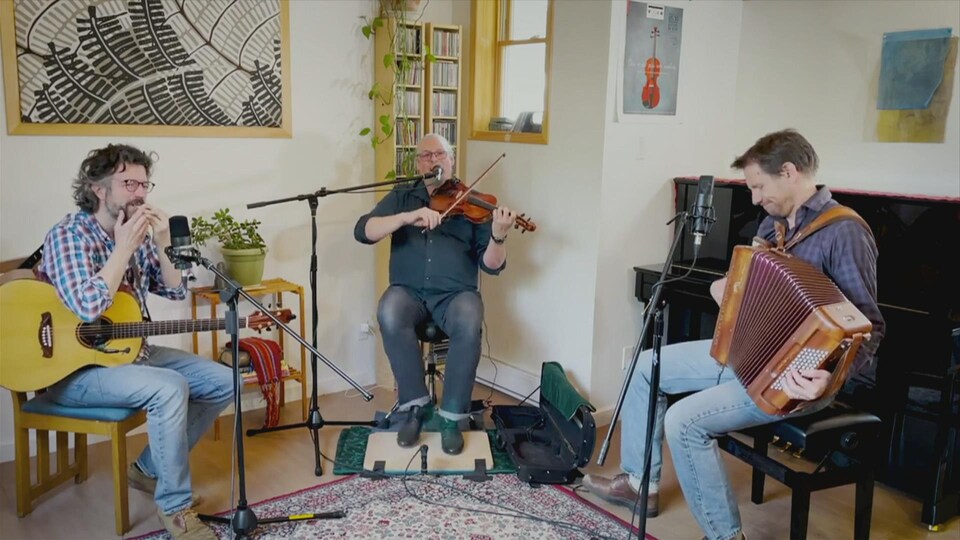 Les trois musiciens de Genticorum qui interprètent une chanson.