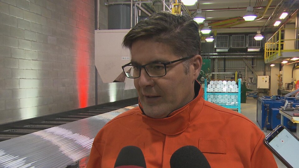 Gervais Jacques se trouve devant quelques microphones dans une usine de Rio Tinto.