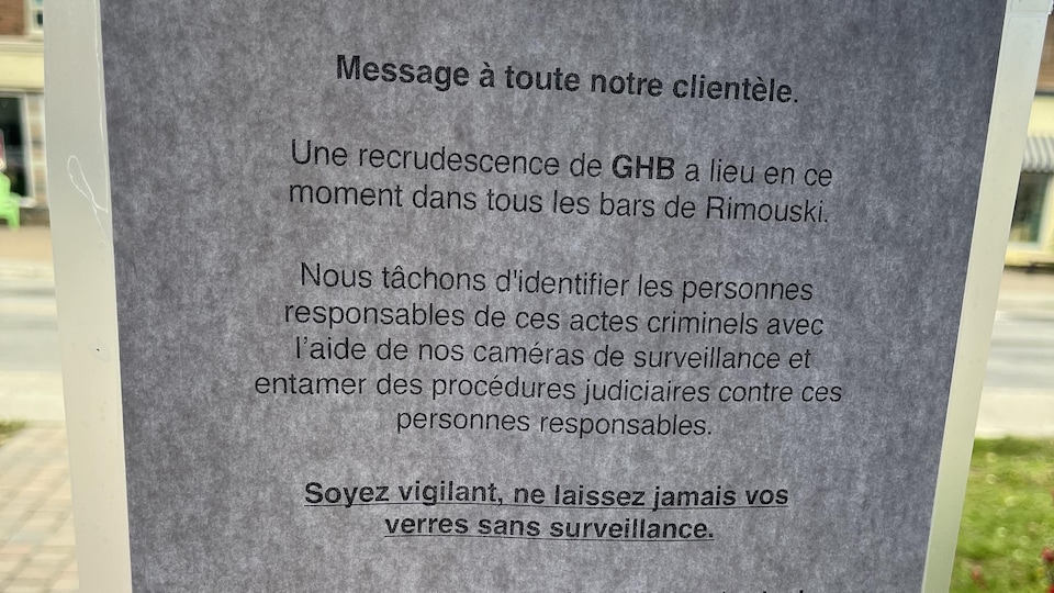 Une affiche indique qu'une recrudescence de GHB a lieu dans les bars de Rimouski. Il est écrit : nous tâchons d'identifier les personnes responsables de ces actes criminels avec nos caméras de surveillance et d'entamer des procédures judiciaires contre ces personnes.