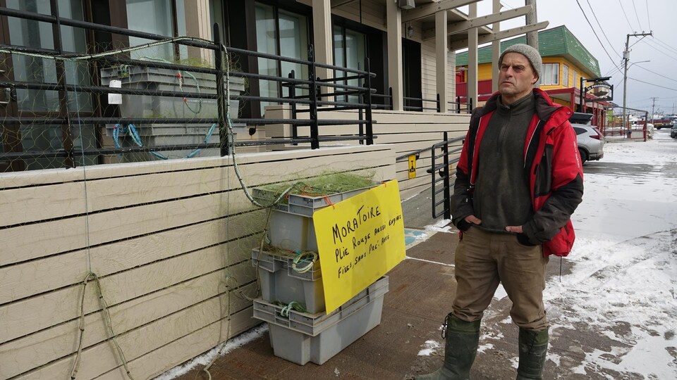 Un homme manifeste devant un bâtiment municipal.