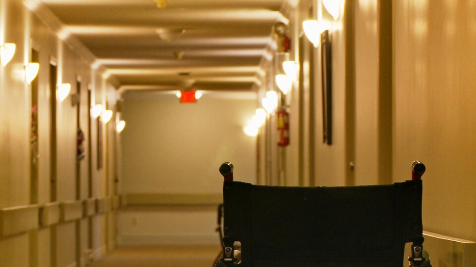 Un fauteuil roulant dans un couloir de maison de retraite.