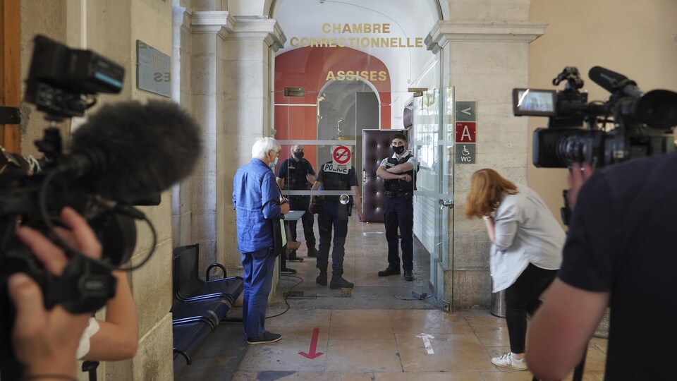 Des caméramans attendent près d'une salle.