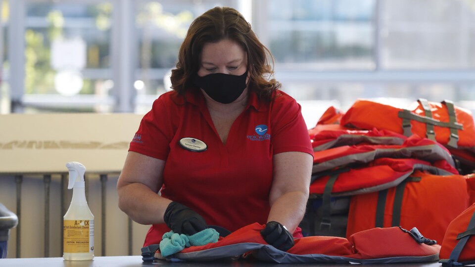 Une dame nettoie des gilets de sauvetage.