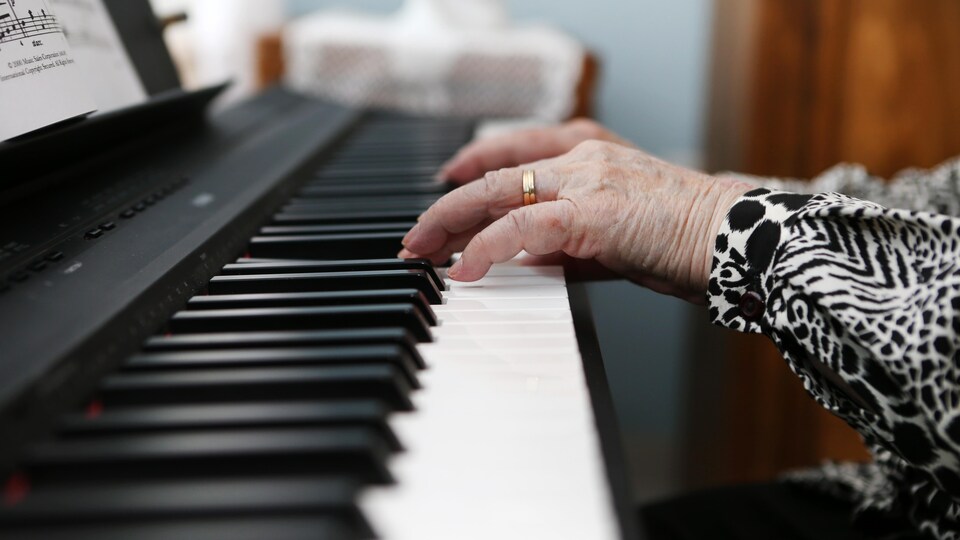Les mains d'une personne pendant qu'elle joue du piano.