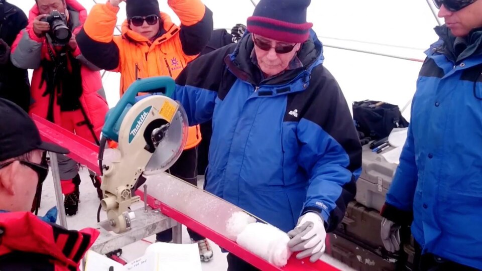 Le Pr Lonnie Thompson découpe une carotte de glace extraite de la calotte glaciaire Guliya.