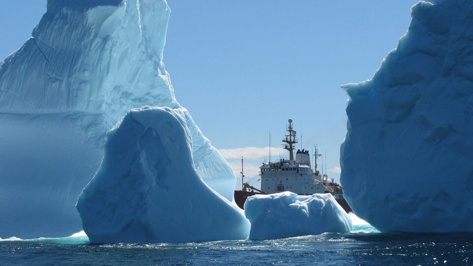 Un navire de la garde côtière vu au travers de plusieurs glaciers dans l'eau. 
