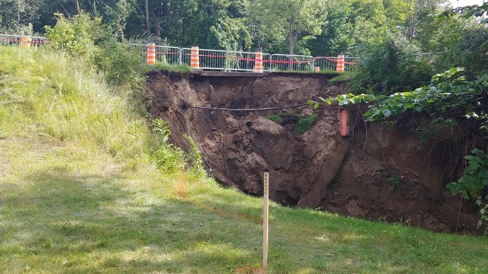 De la terre s'écroule sous une route.