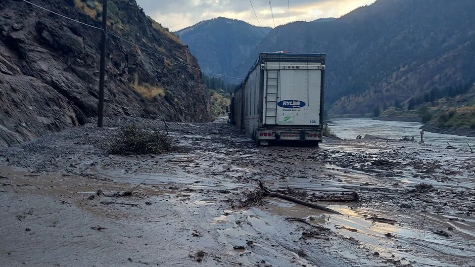 Un camion-remorque repose sur une coulée de boue au bas d'une colline, le 10 août 2022.