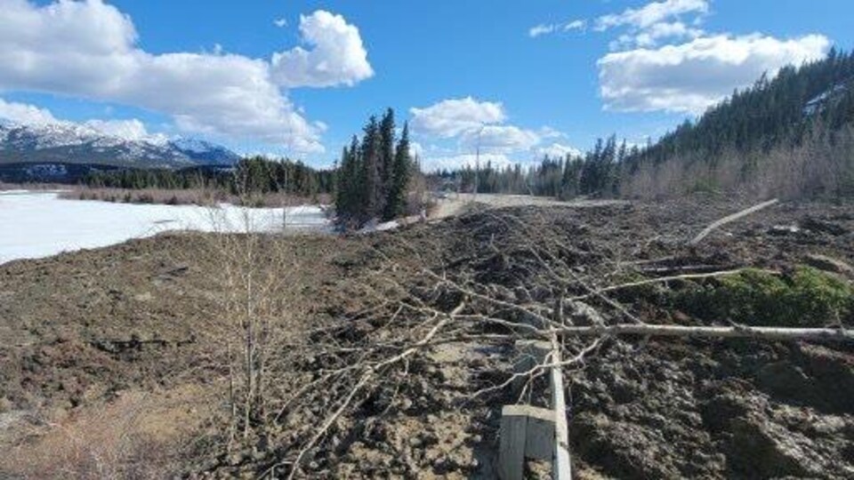 Un amas de terre et de branches recouvre la route Robert Service.