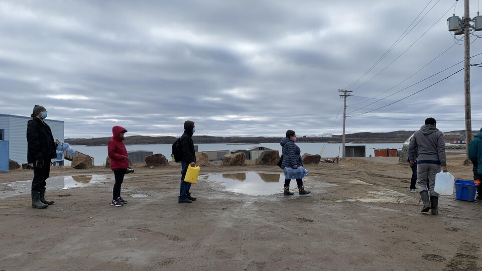 Des habitants d'Iqaluit attendent en rang et en respectant la distanciation physique, le jeudi 14 octobre 2021.