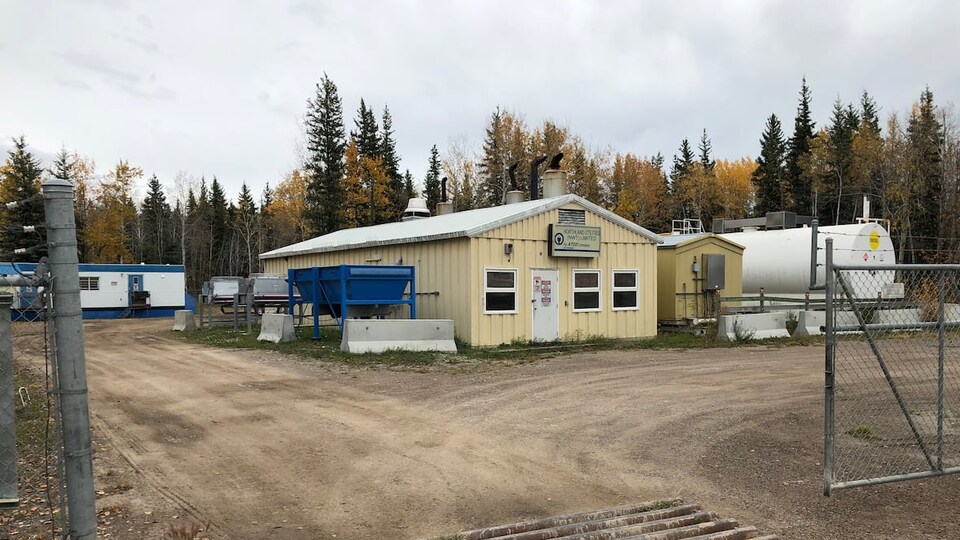 Une centrale électrique et un grand réservoir de carburant dans une forêt.
