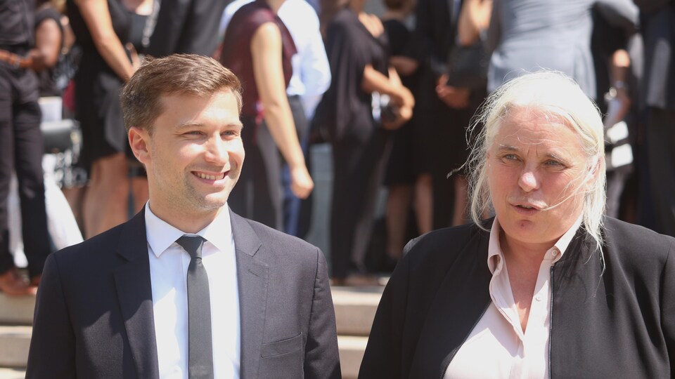 Un homme, souriant, et une femme à la sortie de la basilique-cathédrale, en plein soleil.