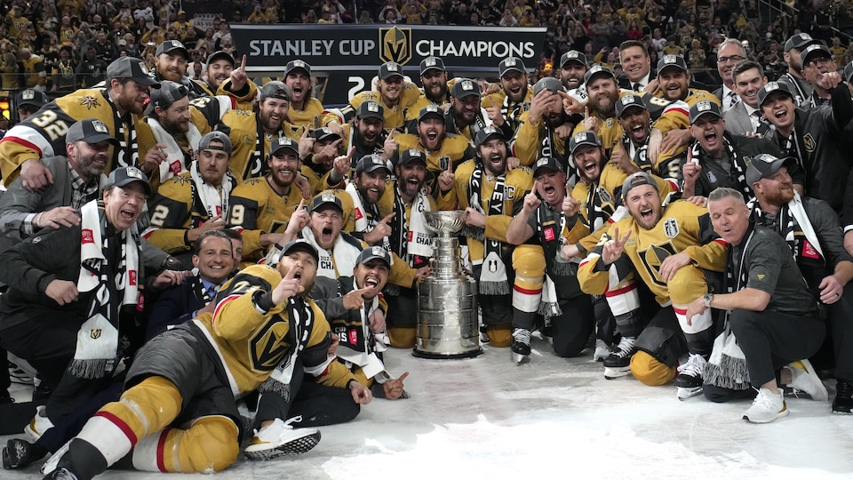 Les joueurs et le personnel des Golden Knights de Las Vegas posent aux côtés de la Coupe Stanley après leur victoire finale en séries éliminatoires.