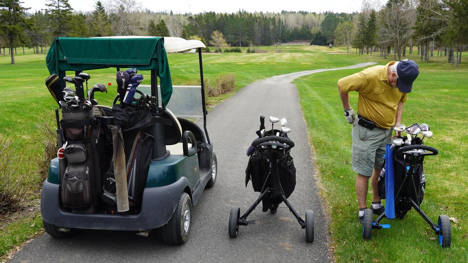 Un joueur regarde ses bâtons dans son sac de golf.