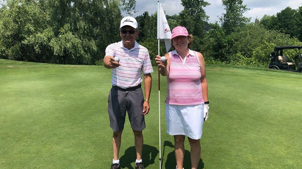 Denis L'Heureux et Linda Carreau au trou numéro 13 tenant fièrement leur balle dans leurs mains.