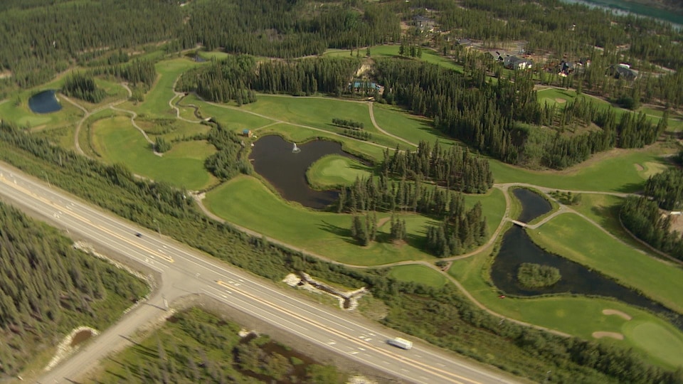 Une vue aérienne d'une route et du terrain de golf Meadow Lakes à Whitehorse