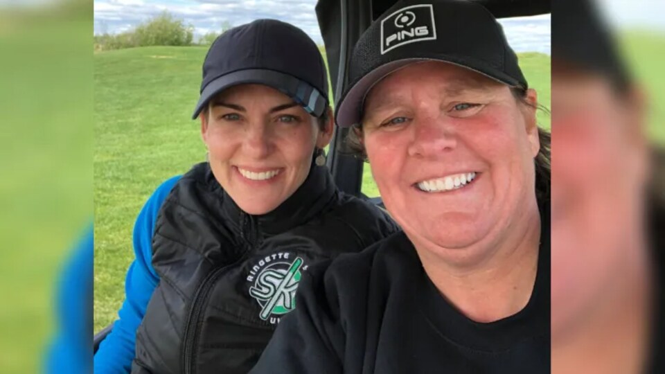 Deux joueuses font un selfie assises dans une voiturette sur un parcours de golf.