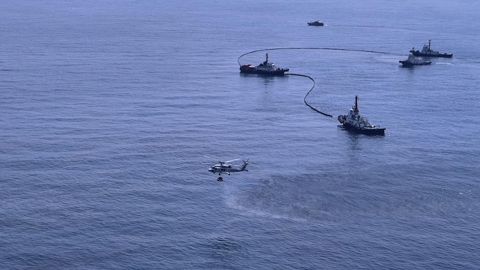 Vue aérienne de bateaux qui tentent d'endiguer le pétrole.