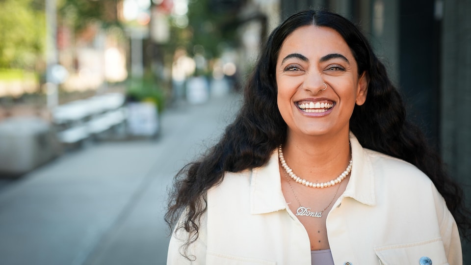 Une femme sourit à la caméra dans les rues de Toronto.