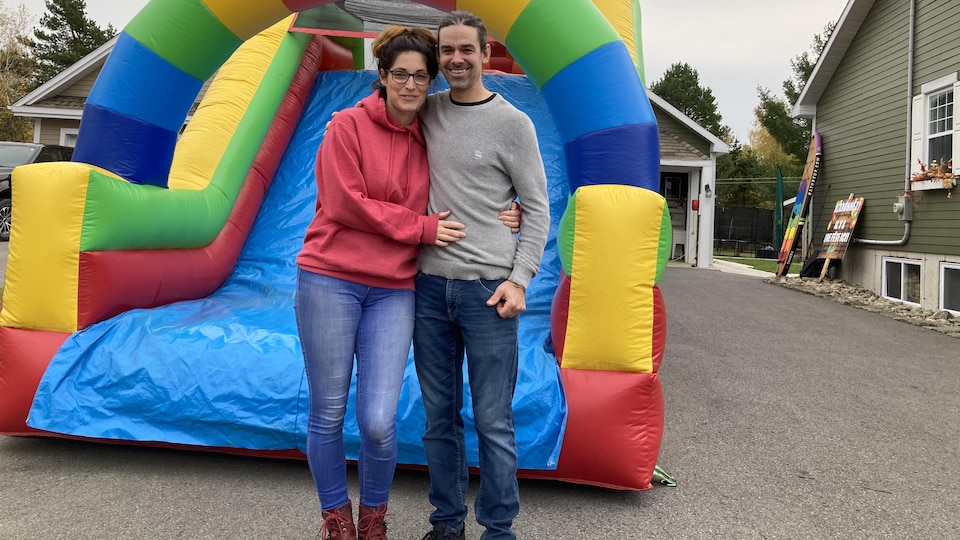 Un homme et une femme devant un jeu gonflable multicolore.