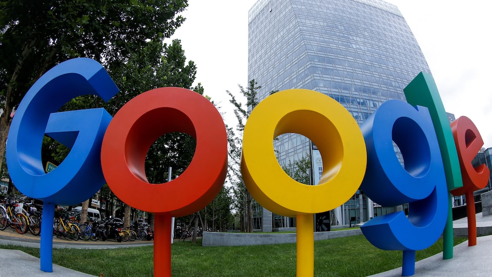 Le logo de Google devant un bâtiment d'une vingtaine d'étages.