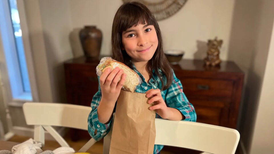 Grace Kennedy, 9 ans, tient un sandwich qu'elle va insérer dans un sac brun.