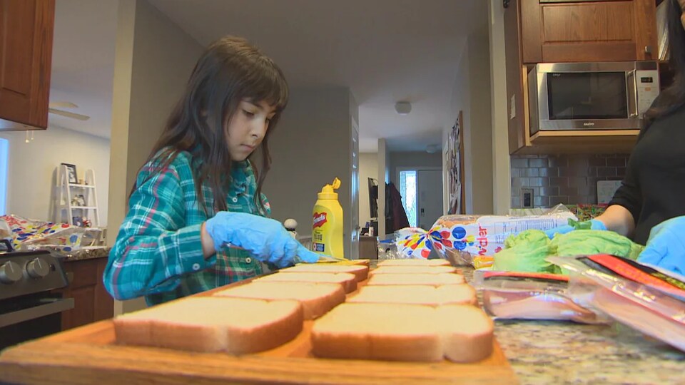 La Manitobaine de 9 ans Grace Kennedy en pleine préparation de sandwichs pour ses colis de bienfaisance destinées aux personnes dans le besoin. 