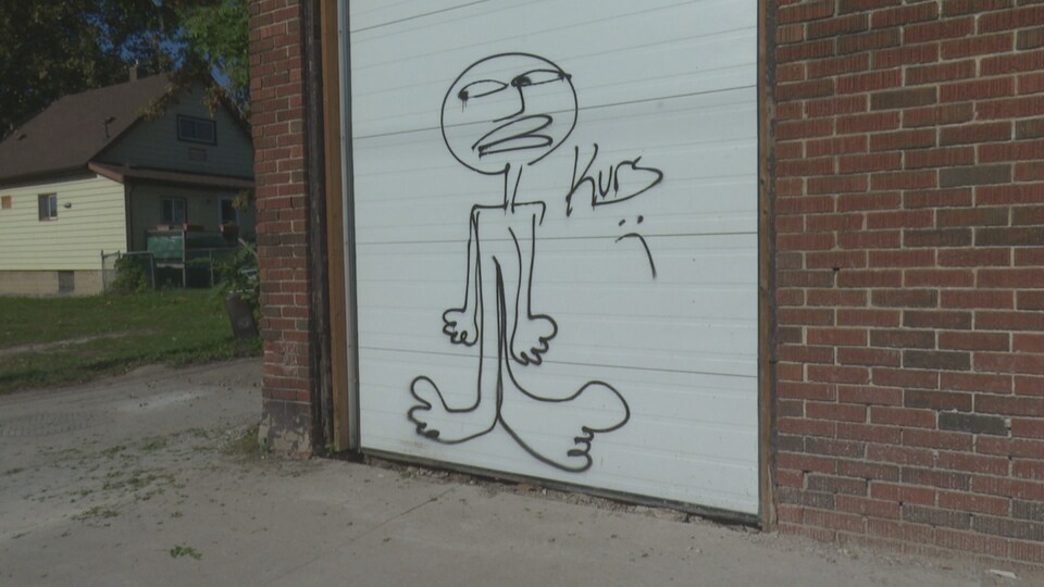 Un graffiti représente un bonhomme. Le dessin est signé Kurs.