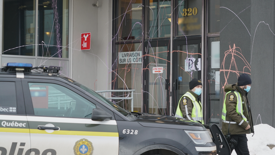 Des policiers devant l'entrée d'un bâtiment aspergé de peinture.